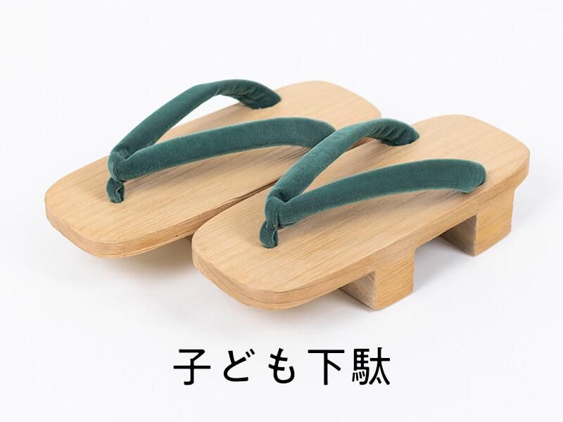 緑の鼻緒が付いた子ども用の二枚歯下駄